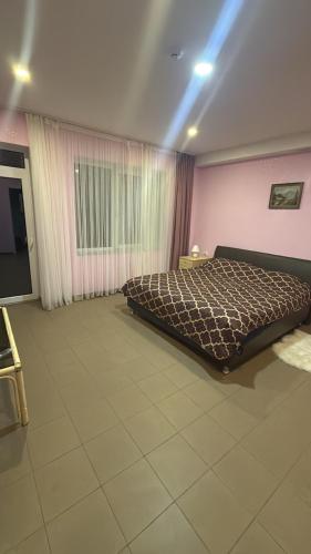 a bedroom with a bed and a pink wall at Bernotiškių Hotel & Dining 