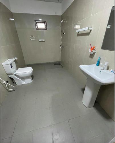 a bathroom with a toilet and a sink at Moringa Villa in Maruthanamadam