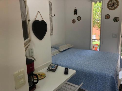 una camera da letto con un letto, un tavolo e una scrivania di Espaço mel a Búzios