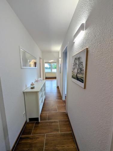 a hallway with white walls and a tile floor at Gemütliche 2-Zimmer-Ferienwohnung mit Garten in Mittenwalde