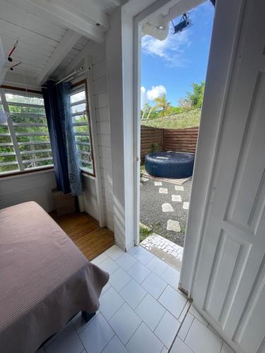 a bedroom with a door leading to a tub at Bungalow Les Gommiers in Saint-François