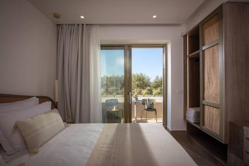 a bedroom with a bed and a view of a patio at Villa Alquimia Aa with private Swimming pool in Hersonissos