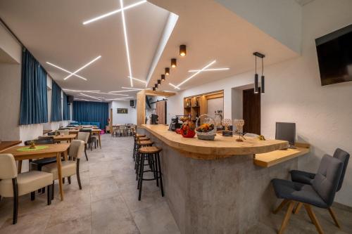 Un bar en un restaurante con mesas y sillas. en Dovalovec Resort, en Liptovský Hrádok