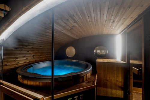 una gran bañera de madera en una habitación con ventana en Dovalovec Resort, en Liptovský Hrádok