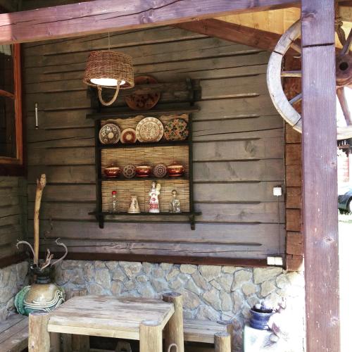 a wooden wall with a table and a shelf with dishes at "Будиночок гедоніста" in Tukhlya