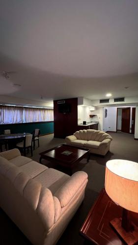 Una sala de estar con dos sofás y una mesa. en Park Hotel Mérida, en Mérida