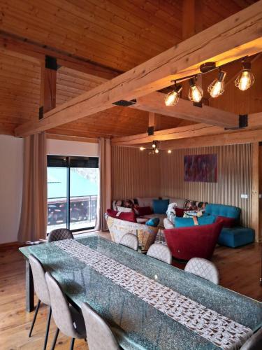 Chalet EGAT في Égat: غرفة معيشة بها طاولة وأريكة