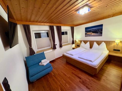 Apartment Lydia في سخلادميخ: غرفة نوم بها سرير وكرسي أزرق