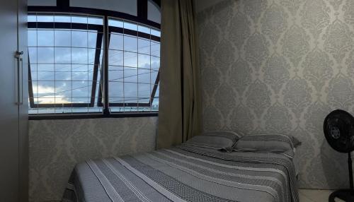 a small bed in a room with a window at Casa Mirante do Mar Floripa in Florianópolis