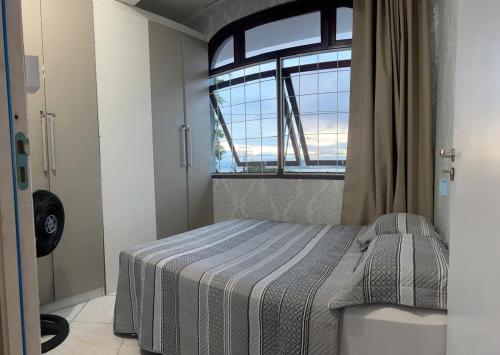 a bedroom with a bed and a large window at Casa Mirante do Mar Floripa in Florianópolis