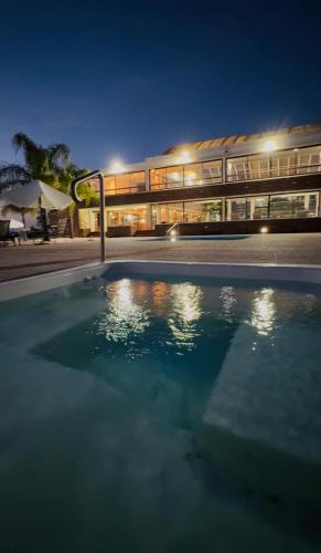 a swimming pool in front of a building at night at Hotel Horacio Quiroga in Termas de Salto Grande