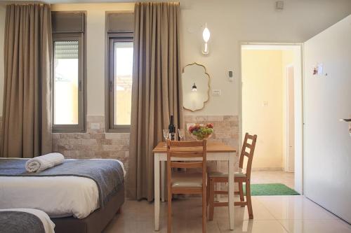 a bedroom with a table and a bed and a dining room at Melony Tsfat in Safed