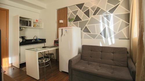 eine kleine Küche mit Couch und Kühlschrank in der Unterkunft Flat com Piscina, Academia e Sauna em Aguas Claras in Águas Claras