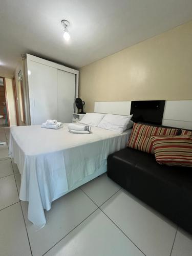 a bedroom with a large bed and a couch at ISRAEL FLAT TAMBAÚ - 102 in João Pessoa