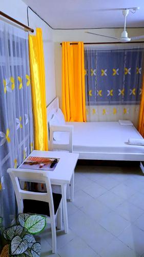 a small room with a bed and a table at Phee home in Mombasa