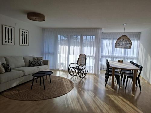 a living room with a couch and a table at Summit View Apartment in Spiez