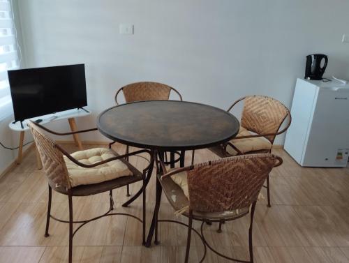 a dining room table with chairs and a television at Cozy cabin for 4 people San Pedro de Atacama in San Pedro de Atacama