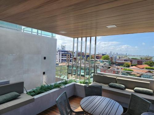 un balcone con tavolo e sedie su un edificio di ISRAEL FLAT TAMBAÚ - 102 a João Pessoa