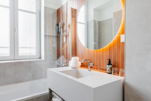 une salle de bains avec un lavabo blanc et un miroir dans l'établissement FortyPlusOne Apartments Vienna, à Vienne