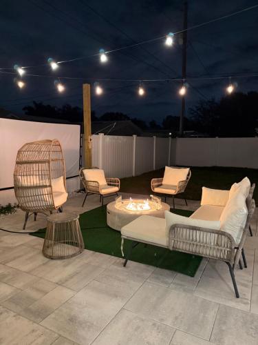 a patio with chairs and a fire pit at night at Madeira Beach Family & Pet Friendly Luxury Getaway in Seminole
