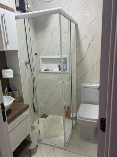 a bathroom with a glass shower with a toilet at Casa com piscina in Tramandaí