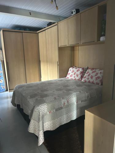 a bedroom with a bed and cabinets in a room at Casa com piscina in Tramandaí