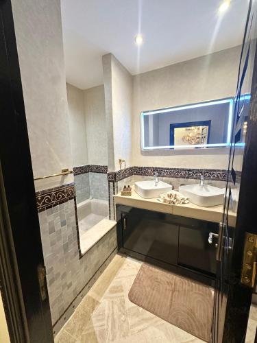 a bathroom with two sinks and a shower at Villa Dar Soka in Marrakesh
