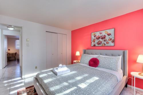 a bedroom with a bed with a red wall at Spacious 2BR ! 6 guest Vacation home Montreal in Montréal