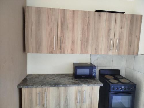 een keuken met een aanrecht met een magnetron en een fornuis bij Manor Rentals in Potchefstroom