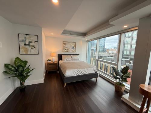 ein Schlafzimmer mit einem Bett und einem großen Fenster in der Unterkunft Waterfront 1 BR corner unit - 6 appliances & gym in Halifax