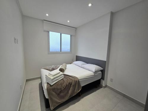 Edifício Infinity - By Housi في فيلا فيلها: غرفة نوم بها سرير بملاءات بيضاء ونافذة