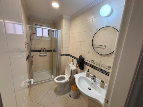 a bathroom with a toilet and a sink and a shower at Large apartment in an idyllic complex, ocean view in Mandria