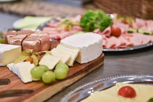 a bunch of cheese and grapes on a cutting board at Hotel Gasthof Süßer Grund in Albstadt