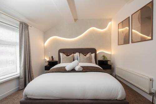 Un dormitorio con una gran cama blanca con un osito de peluche. en New Modern 2 Bedroom Central Apt Greater Manchester, Sleeps 5, Near Airport with Great Transport Links, en Stockport