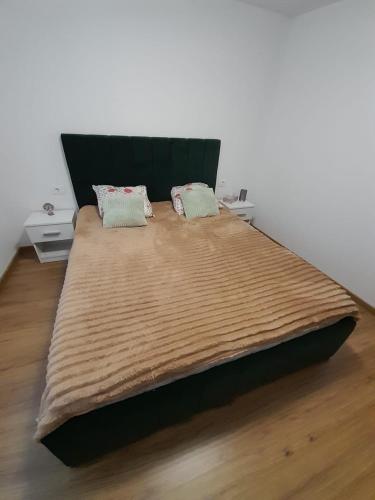 a large bed with two pillows on top of it at Casa de vacanta Gea in Dobra