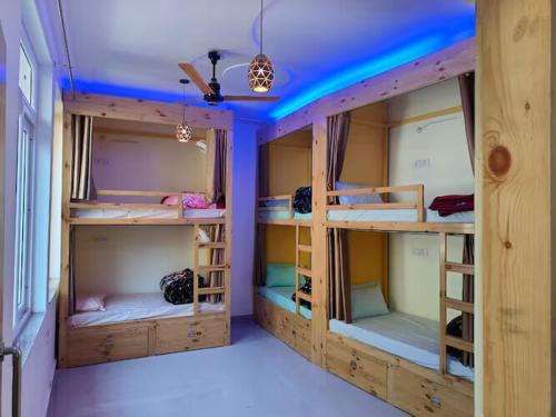 a room with three bunk beds in a room at Solo Nari Backpackers Rishikesh in Narendranagar