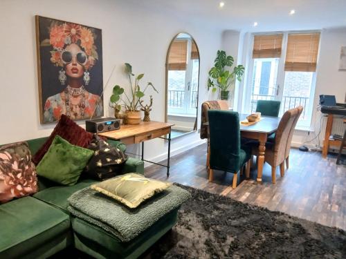 a living room with a green couch and a table at Contractors LONG TERM BOOKINGS in London