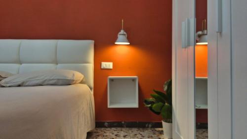 a bedroom with a bed and an orange wall at La Casa di Athina in Celano