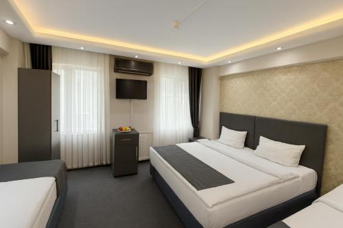 a hotel room with a bed and a television at Grand Sezgin Hotel in Istanbul