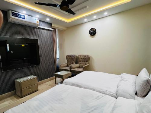 a hotel room with a bed and a flat screen tv at Gateway Resdencia in Islamabad