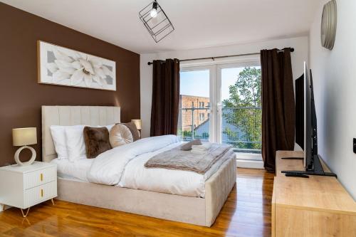 エディンバラにあるLuxury 5BD, Gym, Parking, Bus to Airport, Sleeps10のベッドと大きな窓のある寝室