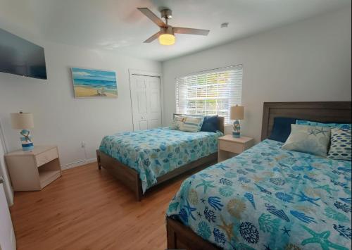 a bedroom with two beds and a ceiling fan at st pete pool house in St Petersburg