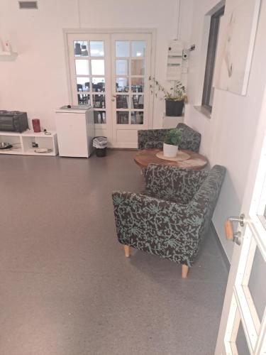 a living room with two chairs and a table at Selmas Pensionat in Vittsjö