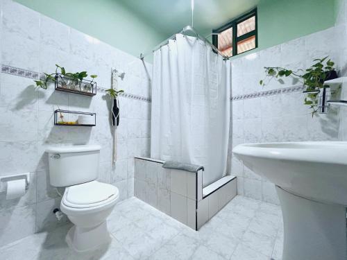 Santa Elena Ventanas Parapente Bed and Breakfast Premium في Santa Helena: حمام أبيض مع مرحاض ومغسلة