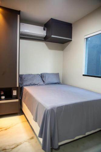 a bedroom with a bed in a room with a window at Aloha flats in Marechal Deodoro