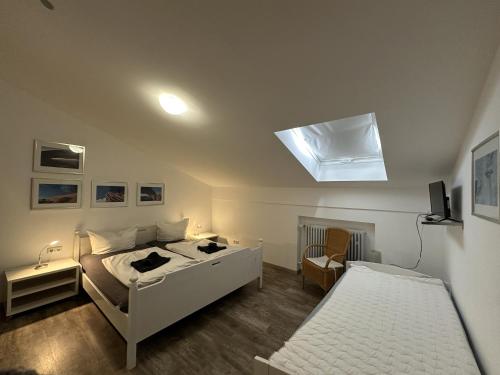 een slaapkamer met twee bedden en een dakraam bij Gschwendtnerhof App14 Ludes-Ennen in Aschau im Chiemgau