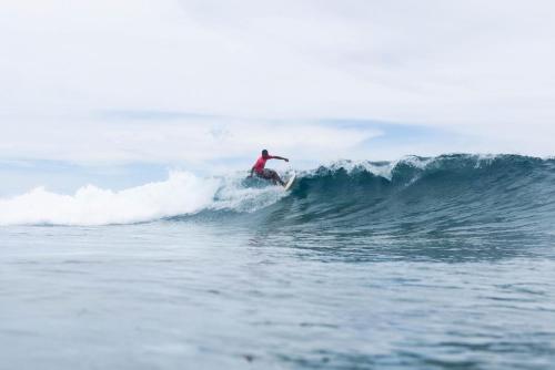 a man riding a wave on a surfboard in the ocean at Sujees surf stay, cloudbreak in Nadi