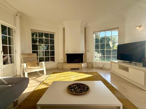 a living room with a fireplace and a tv at Serenity Cascais Villa in Cascais