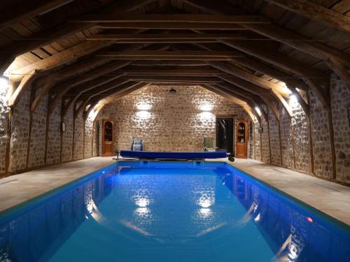 una piscina cubierta en un edificio con una pared de piedra en Chambres d'hôtes - Les Fayards, en Montregard