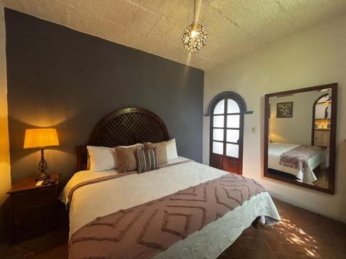 a bedroom with a large bed and a mirror at Hotel Casa Loreto San Miguel de Allende in San Miguel de Allende